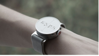 Yakın plan çekilmiş bir kola takılmış olan beyaz Braille alfabeli akıllı saat.
