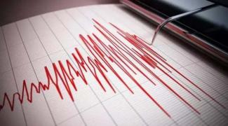 Görselde, masa başında oturan bir kadın, bilgisayar ekranına odaklanmış bir şekilde görünüyor. Ekranda, bir şehrin haritası ve yanında afet yönetimiyle ilgili yazılar, grafikler, kasırga ikonları gibi veriler yer alıyor. Kadın bir eliyle klavye kullanırken diğer eliyle fareyi tutuyor. Masanın üzerinde defterler ve bir kahve fincanı da bulunuyor.